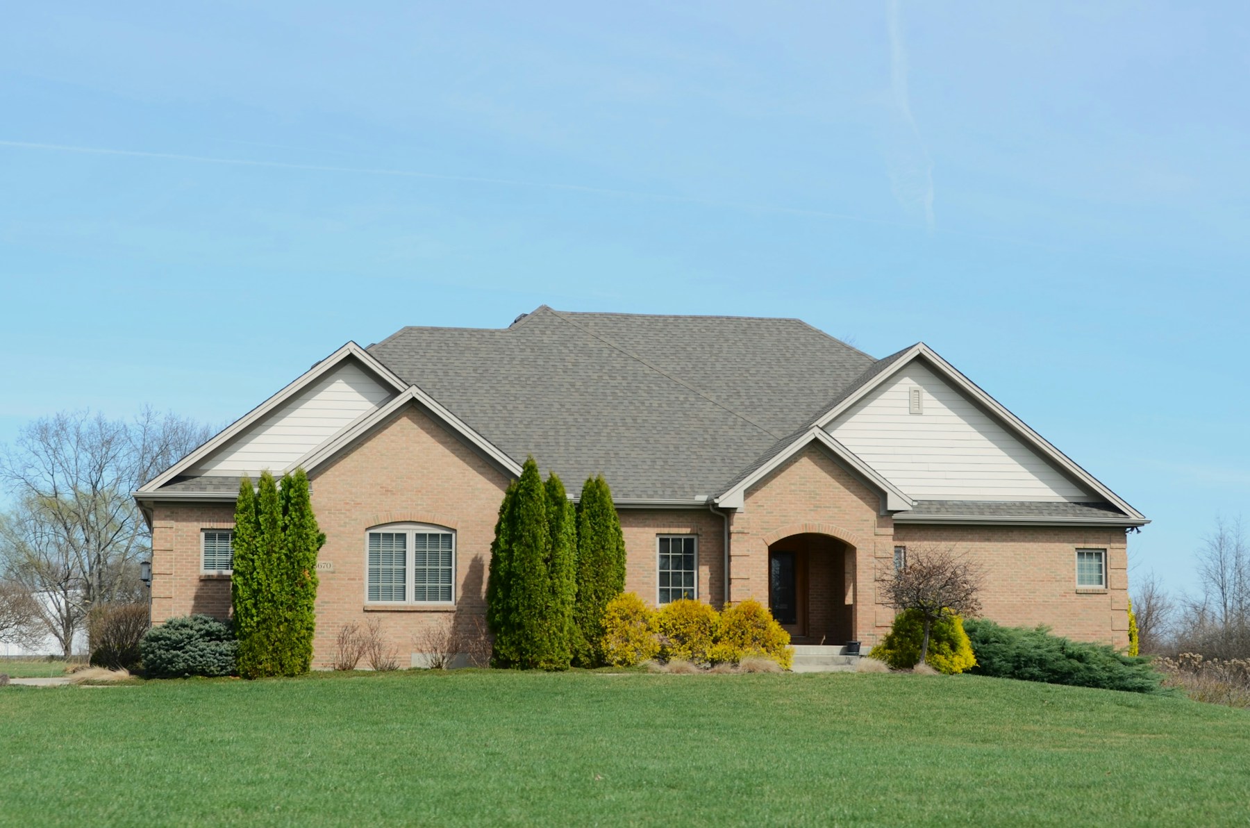 Illustrative brick home with a landscaped front lawn