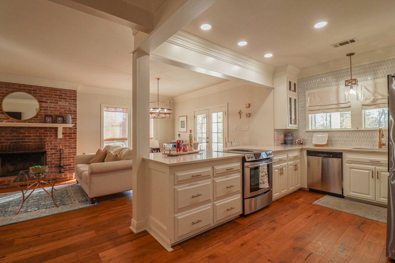 Illustrative kitchen with white cabinets and warm wood floors